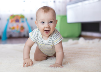 Fototapeta premium funny baby crawling on floor at home