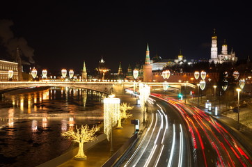 Fototapeta na wymiar Evening view of the Moscow Kremlin, the Big Moskvoretsky bridge and Moskvoretskaya embankment with Christmas illuminations, Moscow, Russia