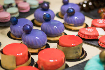 Colorful icing on the cakes. Modern French mousse desserts with mirror glaze. Picture for a menu or a confectionery catalog.