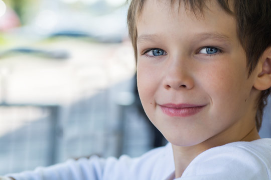 Portrait Of A Beautiful Baby Boy Model In White Clothes With A Kind Look