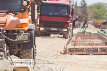 Construction truck / cement mixer and excavator on the heavy construction site.