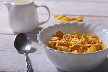 Corn Flakes cereal in a bowl and glass with milk. Morning breakfast.