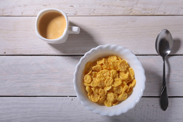 Corn Flakes cereal in a bowl and cap with espresso coffee. Morning breakfast.