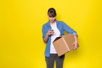 isolated woman on yellow with cardboard box