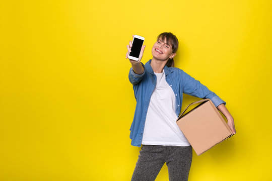 isolated woman on yellow with cardboard box