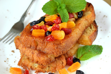 Toasts made of white bread with dried fruits and mint topping. Breakfast meal