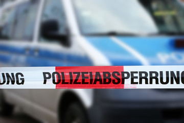 Polizeiabsperrung mit Polizeiauto im Hintergrund