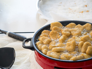 Nuggets in a red electric pan and the oil is boiling. The nuggets for outdoor party.