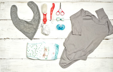 Conjunto de ropa y artículos para  bebé sobre un fondo de madera