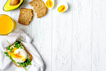 Fotobehang sandwich with poached eggs on wooden background top view mockup © 279photo