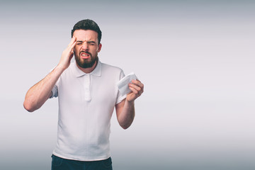 Naklejka premium studio picture from a young man with handkerchief. Sick guy isolated has runny nose. man makes a cure for the common cold.Nerd is wearing glasses