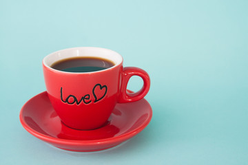 Close up of red cup of hot coffee with LOVE word on pastel color background