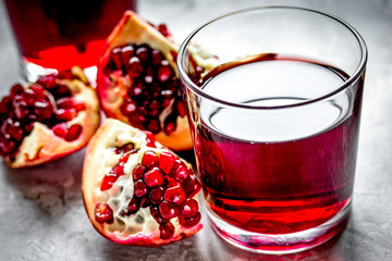 fresh pomegranate with juice in glasses on kitchen background
