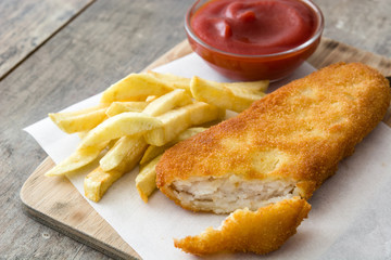 Traditional British fish and chips on wooden table.