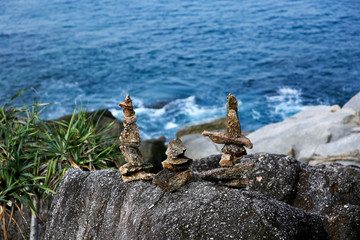 Symbolic scales of stones against the background of the sea and blue sky. Concept of harmony and balance. Pros and cons concept
