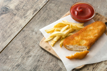 Traditional British fish and chips on wooden table.