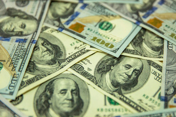 One hundred dollars pile as background.