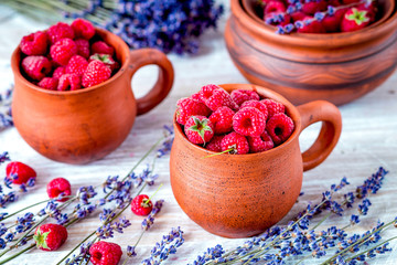 raspberry composition in pottery with dry lavender rustic backgr