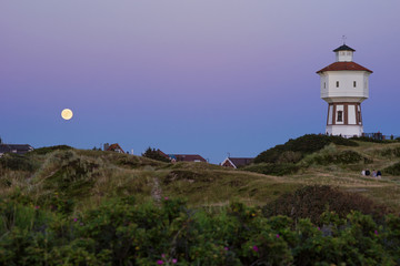 Wasserturm zwischen den Dünen auf Langeoog mit Mond