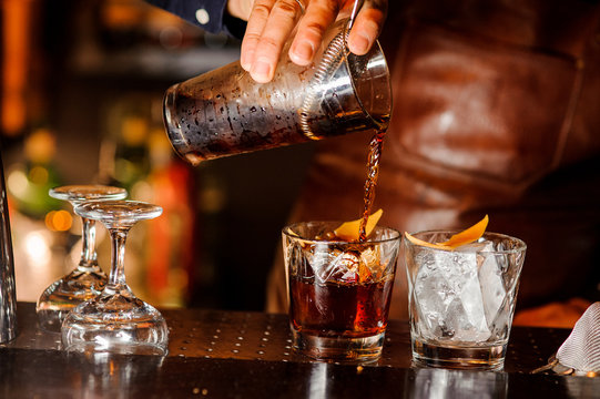 Barman Pouring Alcoholic Drink Into The Glasses