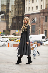 Fototapeta premium Portrait of a young beautiful woman in gray coat
