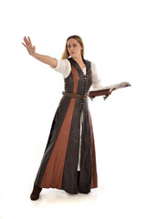 Fototapeta premium full length portrait of girl wearing brown fantasy costume, holding a book. standing pose on white studio background. 