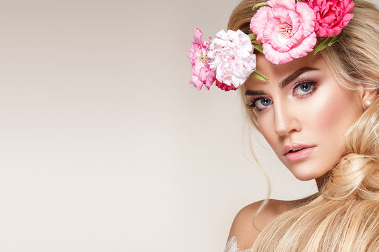 Beautiful woman portrait with long blonde hair and flowers on head. Tender bride.