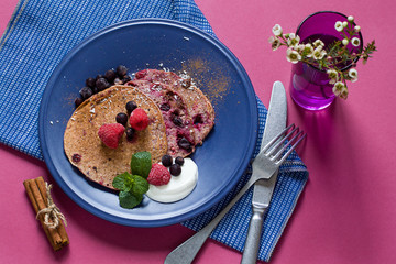 Healthy skinny homemade pancakes are made with banana smoothie, oats, cocoa   powder and berries on the plate. Sugar free morning breakfast    Close up. Top view