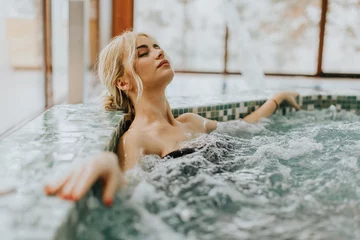 Fotobehang Young woman relaxing in the whirlpool bathtub © BGStock72