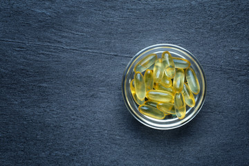 Vitamine D gel capsules on dark background