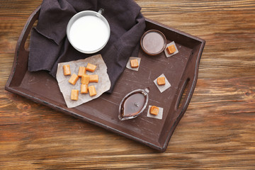 Composition with tasty candies and caramel sauce on table