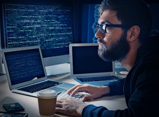 Young man hacking server in dark room