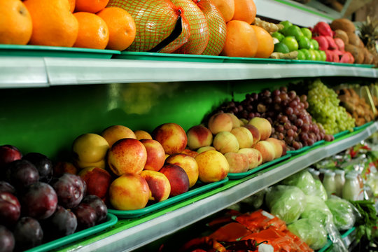 Variety of different fruits and vegetables on shelves in supermarket