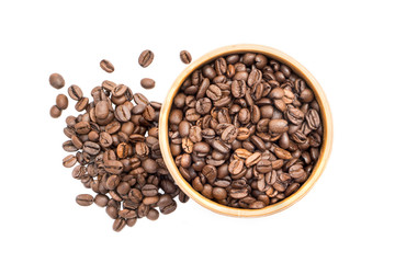 Coffee beans in a wooden bowl with a pile next to it seen from above isolated on white background