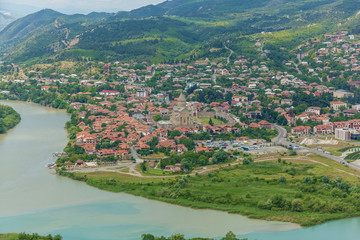 Fototapeta na wymiar The Top View Of Mtskheta, Georgia, The Old Town Lies At The Confluence Of The Rivers Mtkvari And Aragvi. Svetitskhoveli Cathedral, Ancient Georgian Orthodox Church, Unesco Heritage In The Center