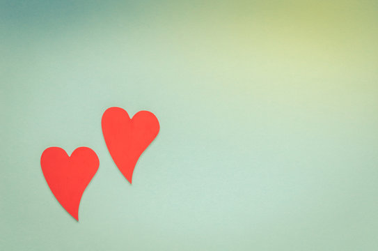 Two wooden red hearts on blue background