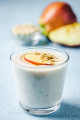 Caramel apple overnight oat smoothie in glasses on light blue background. Selective focus, space for text. 