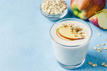 Vegan coconut apple oat smoothie in glasses on light blue background. Selective focus, space for text. 