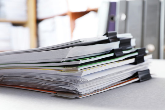 Stack of folders with documents on table in archive