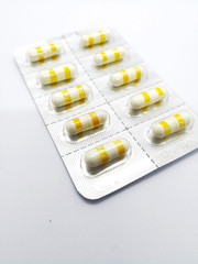 Medication concept. Celecoxib is  a nonsteroidal anti-inflammatory drug , white-yellow capsules are in silver blister. Sealective focus, Isolated on white background and copy space.