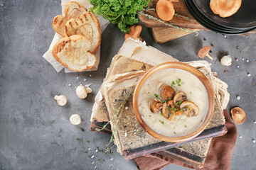 Bowl with mushroom soup on old books