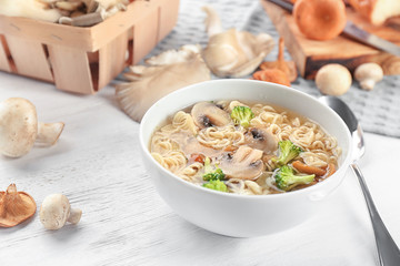 Bowl with mushroom soup on table