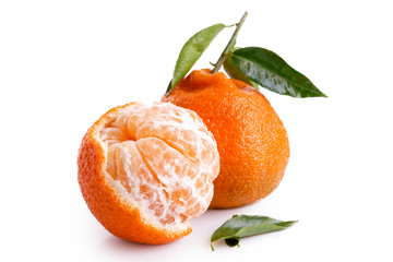 One half peeled and one whole mandarin with leaves isolated on white.