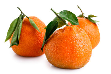 Three whole mandarins with leaves isolated on white.