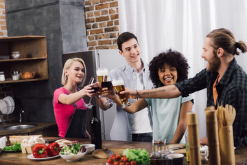 multiethnic friends clinking with glasses of wine and beer