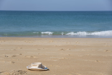 Fototapeta na wymiar A hat and a smartphone on beautiful beach