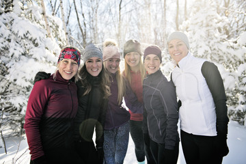 Group of friends enjoying jogging in the snow in winter