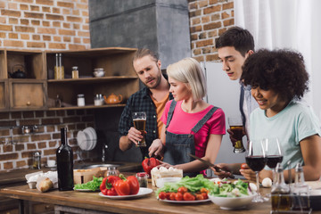 men with beer looking how multiethnic girls cooking