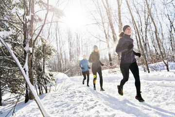 Group of friends enjoying jogging in the snow in winter
