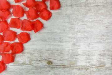 red flower petals on a light wooden table